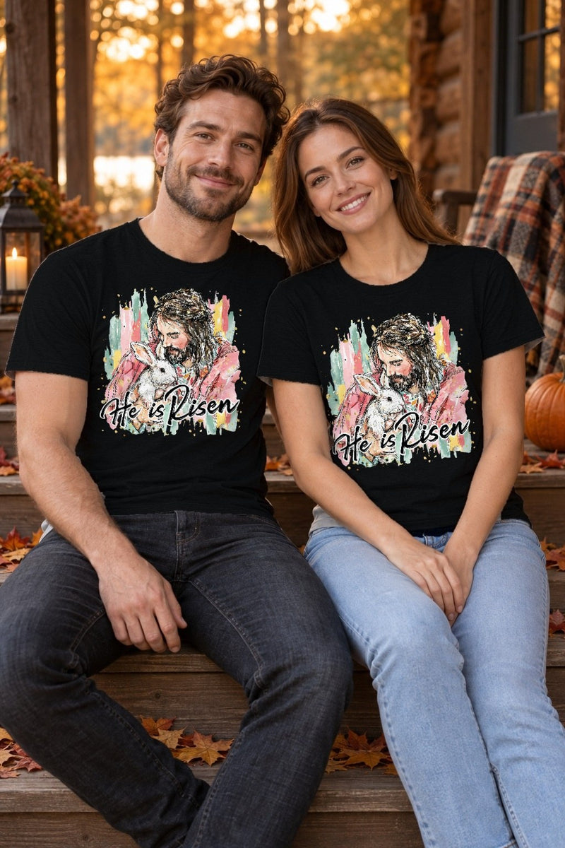 Christliches Oster T-Shirt „He Is Risen“ – Jesus hält ein weißes Häschen im …